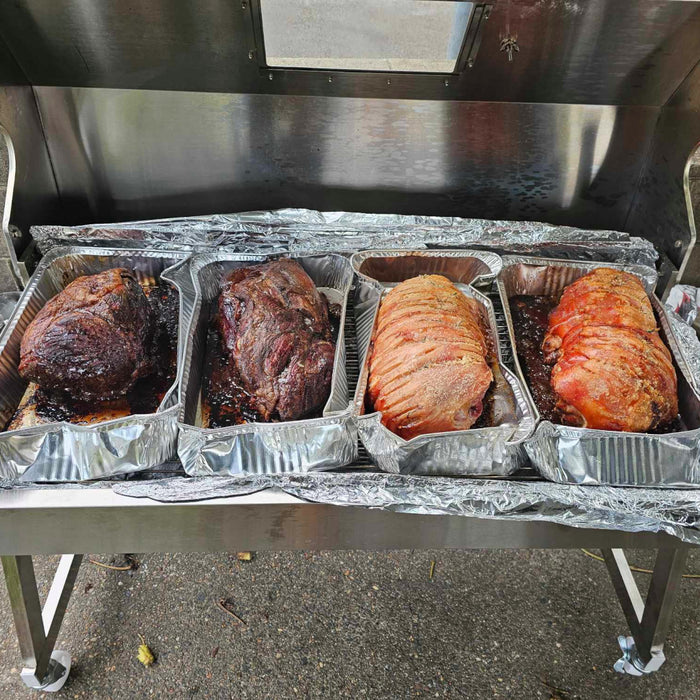 1200 spartan hooded charcoal spit used as an oven with pork and beef slow cooking