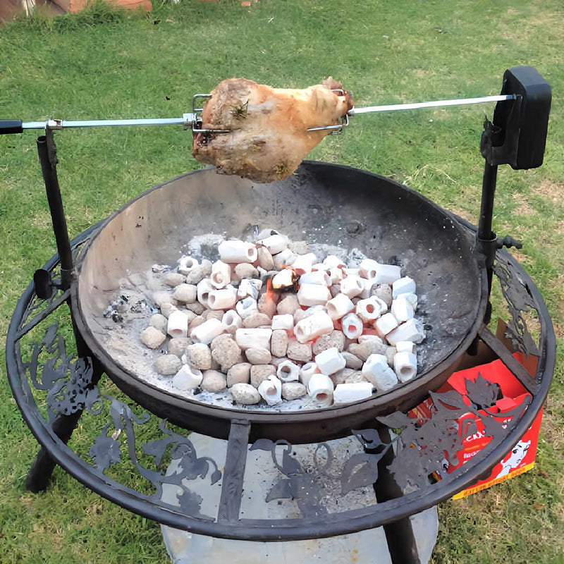 BBQ Grill and Fire Pit full of heat beads with a lamb roast on rotisserie