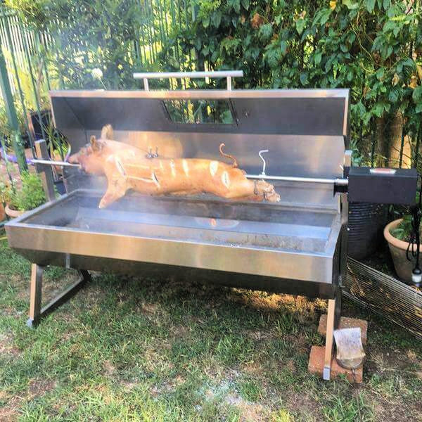 A whole pig cooking on a spit using the 1500 mm spartan Hood spit rotisserie