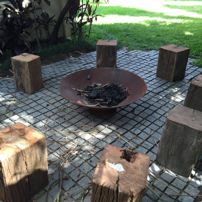 Cauldron cast iron fire pit in a backyard with wood seating