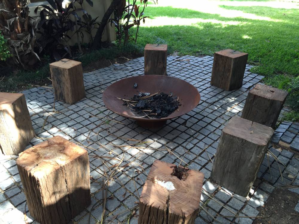 Cauldron cast iron fire pit in a backyard with wood seating