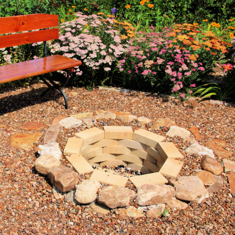 fire pit in built into ground with fire bricks adn stones surrounding it