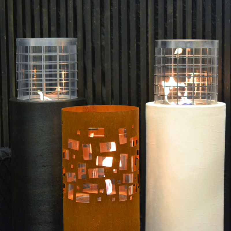 Ethanol fire pits of different types and colours alight and on display outside a store