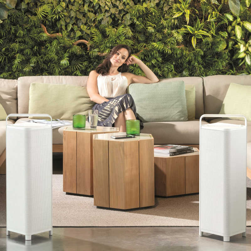 A lady sitting outside in an outdoor area with two escape audio speakers