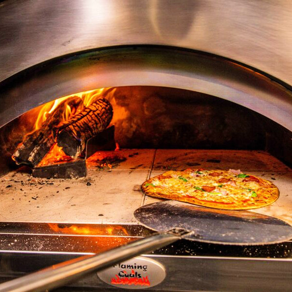 pizza oven peel inside a pizza oven collecting a cooked pizza