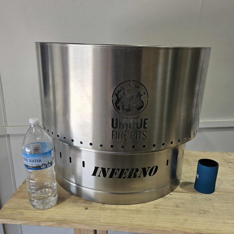 Smokeless Fire Pit With FREE Grill, Lid and Carry Bag showing the 650 mm showing it near a watter bottle and cooler for size comparison