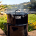 Pit Barrel Smoker & Cooker front view of barrel with branding showing with smoke coming out of the hanger rod holes