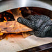 Heat Resistant Gloves | close up view of placing wood into a pizza oven with gloves on
