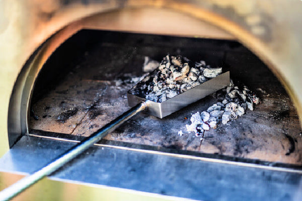 Pizza Oven Tool Kit | showing how the pizza oven shovel can pick up the leftover coals