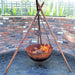 Tripod Fire Pit front view with fire inside near brick wall