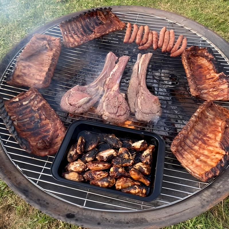 Outdoor Fire Pit Bundle | Cauldron Hearth with Grill | Stainless Steel with food on cooking including steaks sausages and wings