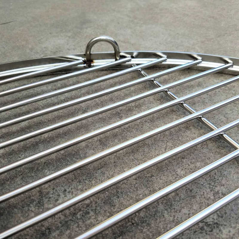 Fire Pit Accessory Stainless Steel BBQ Grill close up on ground partial view