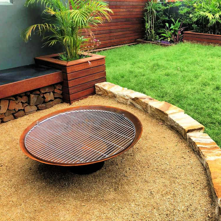 Fire Pit: The Cauldron Hearth with stainless steel bbq grill on it