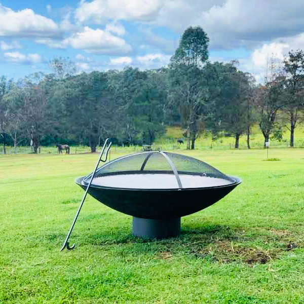 Fire Pit Accessory: Ember Screen on Stainless steel Cauldron hearth with a Fire Poker leaning against it