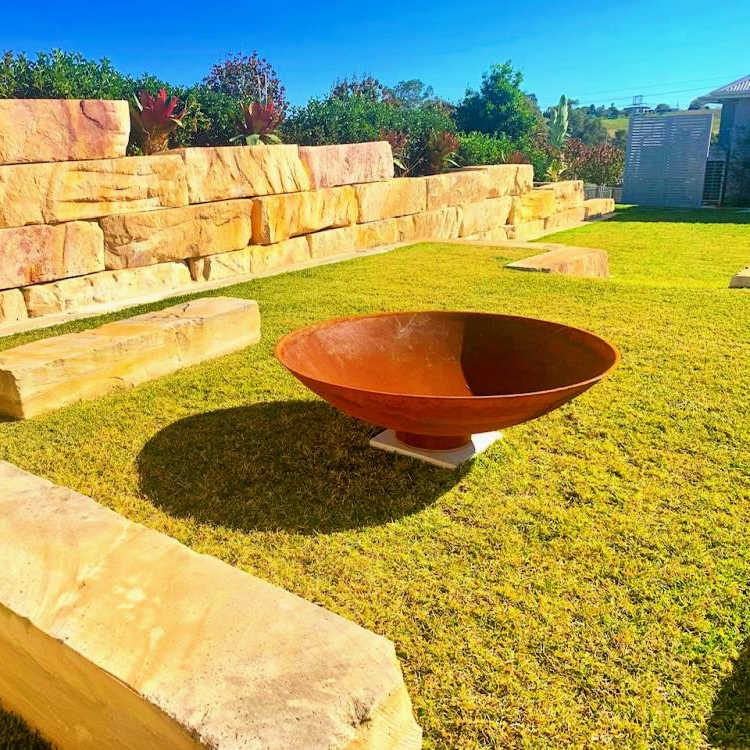 Fire Pit: Mega Cauldron in back yard with sandstone wall and seating
