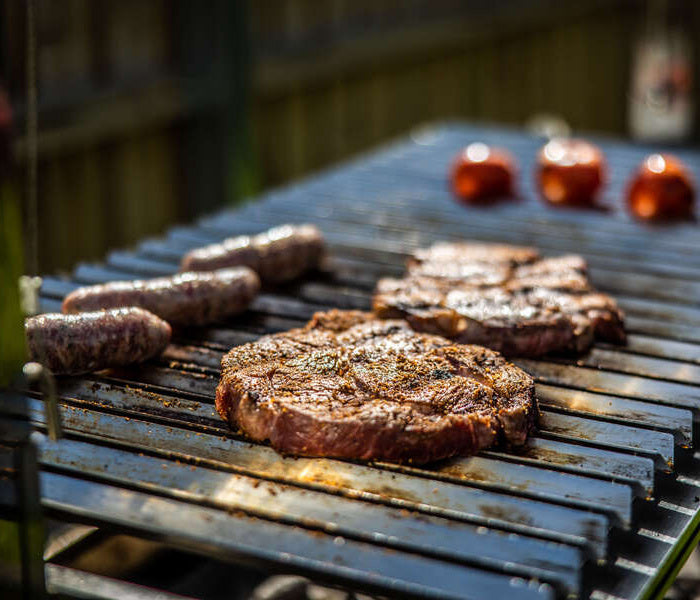 Products Parrilla BBQ Grill Deluxe with Firebricks cooking meat