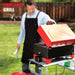 Portable Pellet Grill in Apple Red rear view with lid open and a person grilling food on it